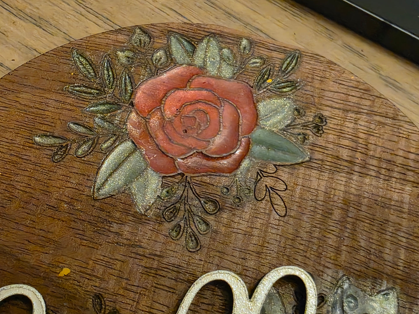Decorative rose design on a wooden surface