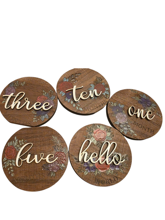 Set of five wooden coasters with floral designs and text on a white background
